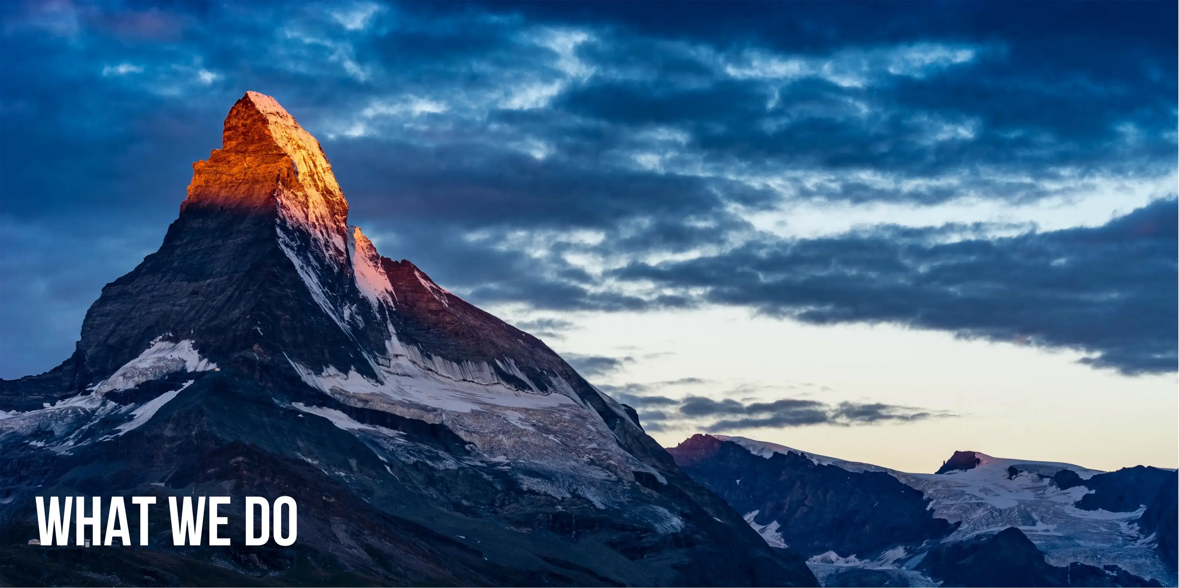Mountain peak with dramatic lighting against a cloudy sky